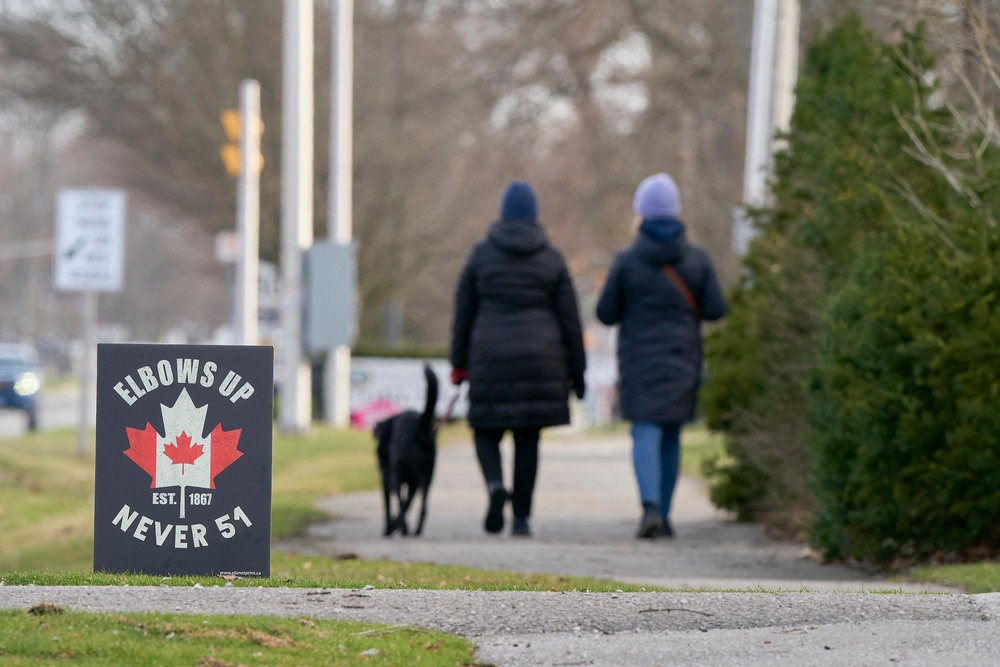 Recent polls show that many Canadians now view their southern neighbor unfavorably. Pictured: People walk past a sign protesting President Donald Trump's comments that Canada should become the 51's State in Corunna, Ontario, on April 1, 2025 (AFP via Getty Images)
