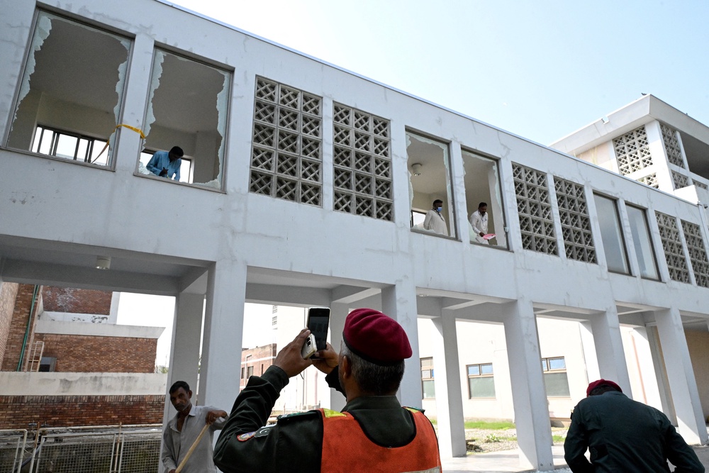 Workers remove shards of broken windows following a fire incident outside the Mother and Child Health (MCH) ward at the Pakistan Institute of Medical Sciences (PIMS) Hospital (AFP/Getty)