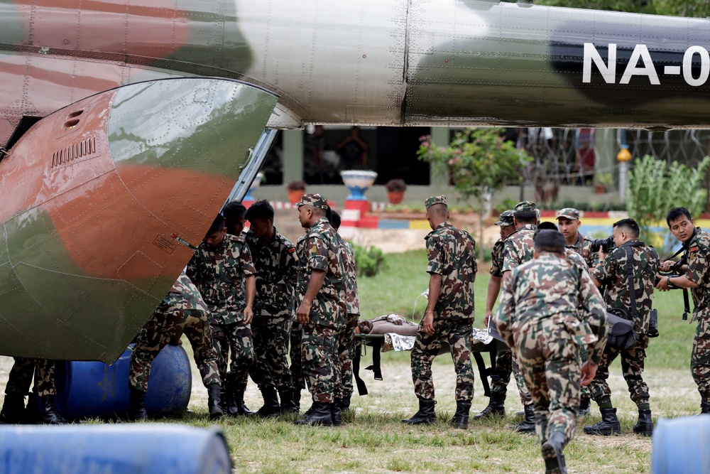 Members of the Nepali Army carry a survivor who is being airlifted following a flash flood at Trishuli in Nuwakot district, Nepal (Reuters)