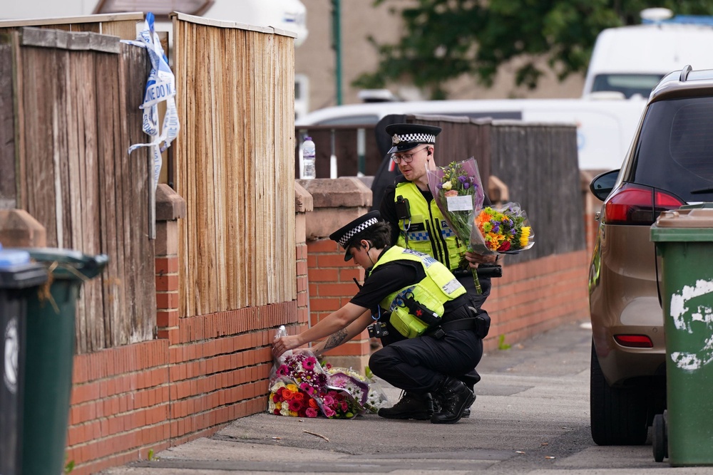 Police lay flowers and tributes at the house (Getty)