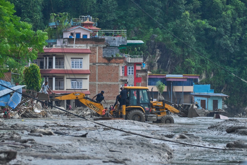Rescuers use earthmovers to reach submerged houses after flash flooding along the Trishuli River in Nepal’s Nuwakot district (Niranjan Shrestha/AP) (AP)