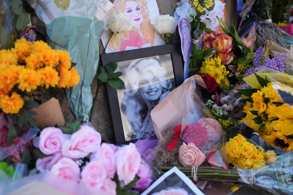 Images and flowers form a makeshift memorial honouring Dolly Parton in front of her statue in Sevierville, Tennessee (Copyright 2026 The Associated Press. All rights reserved.)