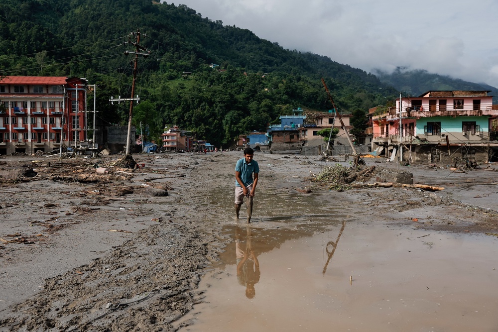 A man wades through muddy waters following devastating floods, in Trishuli in Nuwakot district, Nepal, August 27, 2026 (Reuters)