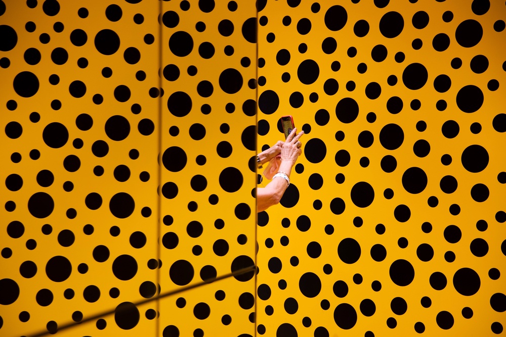 A woman takes a photo during her visit at the art work 'The Spirits of the Pumpkins Descended into the Heavens' by Yayoi Kusama. (Copyright 2021 The Associated Press. All rights reserved)