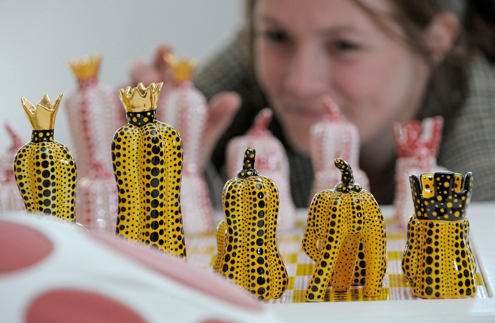 Exhibition assistant Kathrin DuBois of the Museum Ludwig in Cologne arranges chess board figures of the installation 'Pumpkin Chess' in the Porzellanikon Museum in Selb, southern Germany. (2010 AP)