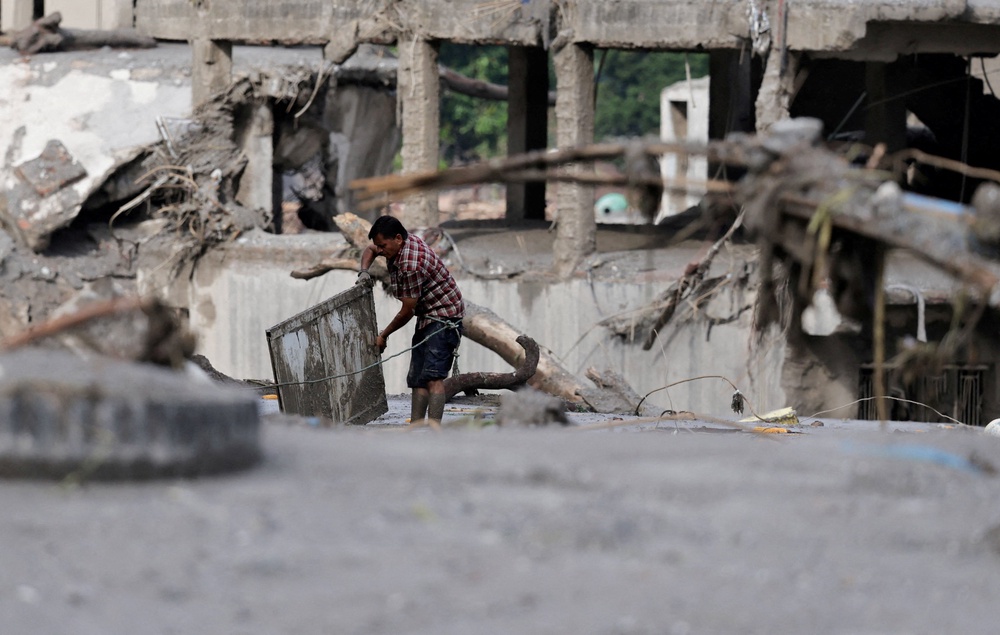 A man salvages his belongings from mud following devastating floods, in Trishuli in Nuwakot district, Nepal, August 27, 2026 (Reuters)