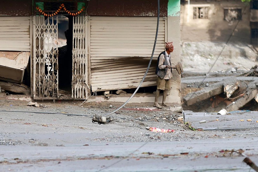 A local resident stands along a street lying deluged in sludge after flash floods near Devighat, Bidur Municipality in Nepal's Nuwakot district on August 27, 2026. Nepal's disaster agency said that 823 people remained out of contact on August 27, more than 24 hours after a deadly flood tore through the border region with Tibet (AFP/Getty)
