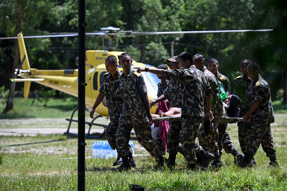 Army personnel rescue flood-affected residents using a helicopter following flash floods, as they arrive at an army camp in Battar Bazar town in Nepal's Nuwakot district (AFP/Getty)