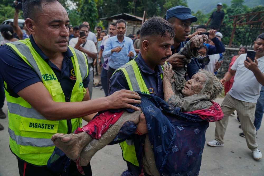 Rescuers carry a victim of flash flooding to safety along the Trishuli River in Nepal’s Nuwakot district (Niranjan Shrestha/AP) (AP)