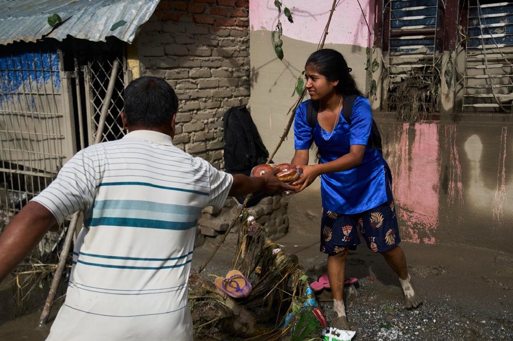 A girl collects food in the aftermath of flash floods in Devighat in the Nuwakot district in Nepal, Thursday, Aug 27, 2026 (AP)