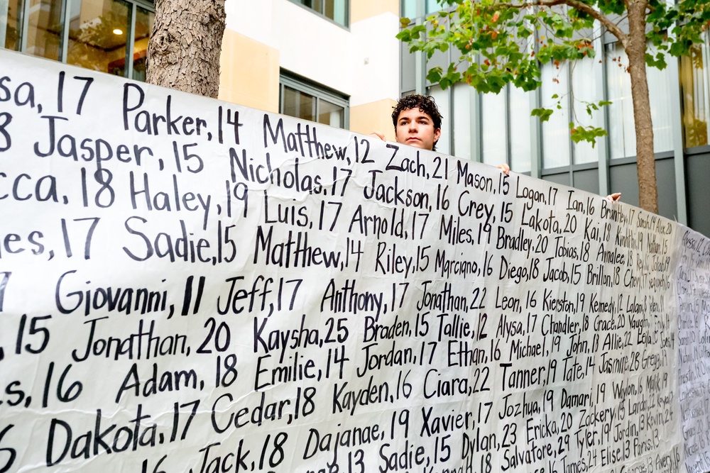 A campaigner holds a banner with names of young people who advocates say died as a result of social media in California, US (Noah Berger/AP) (AP)