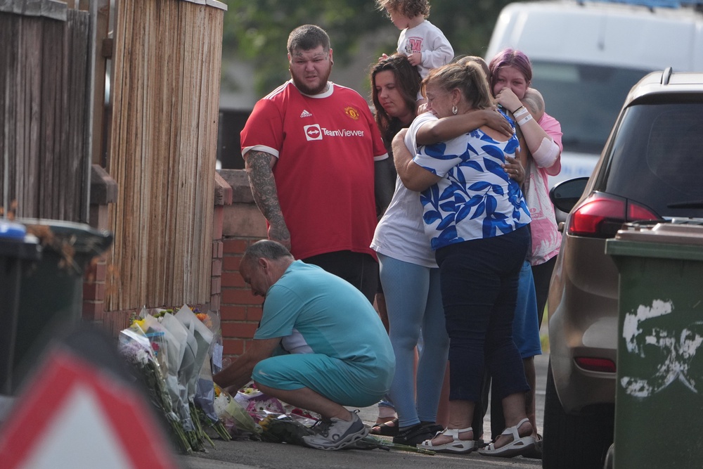 People lay flowers at the scene on Birchington Avenue, Grangetown (Owen Humphreys/PA) (PA Wire)