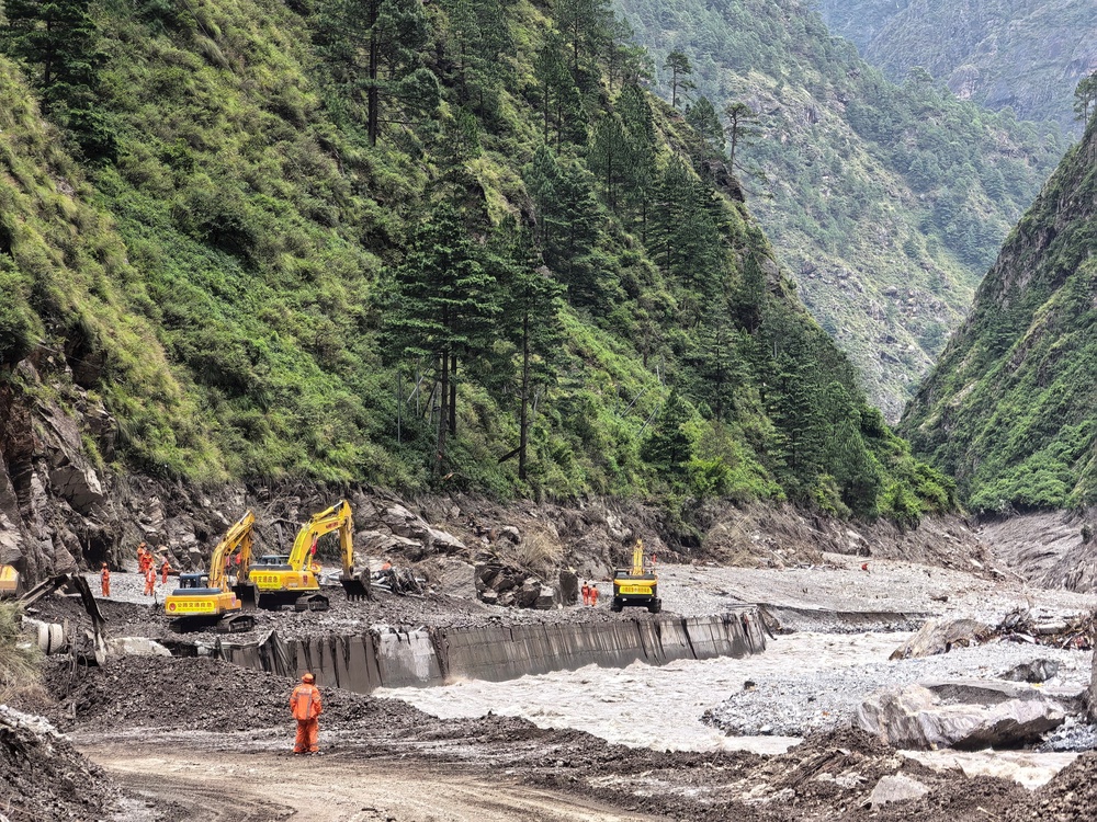 Workers repair a damaged road in Tibet (Reuters)
