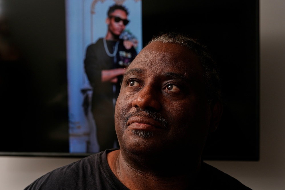 Evaniel Johnson poses with a picture of his grandson, Tyrin (Copyright 2026 The Associated Press. All rights reserved)