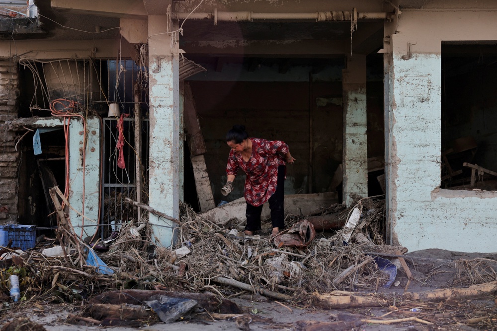 A woman searches for her belongings at a damaged shop following flash floods and a mudslide in Trishuli, Nuwakot district, Nepal, 28 August 2026 (Reuters)