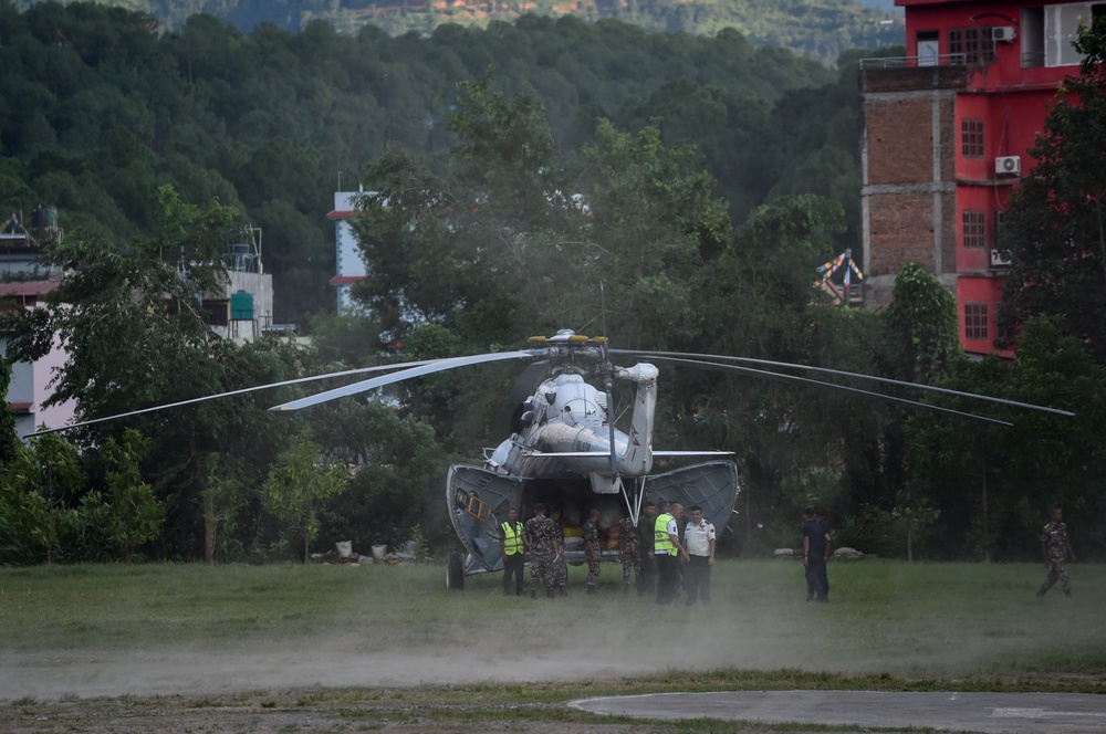 Rescuers and personnel assist airlifted residents at an army rescue camp in Trishuli Batar, Nepal, on 27 August 2026 (Getty)