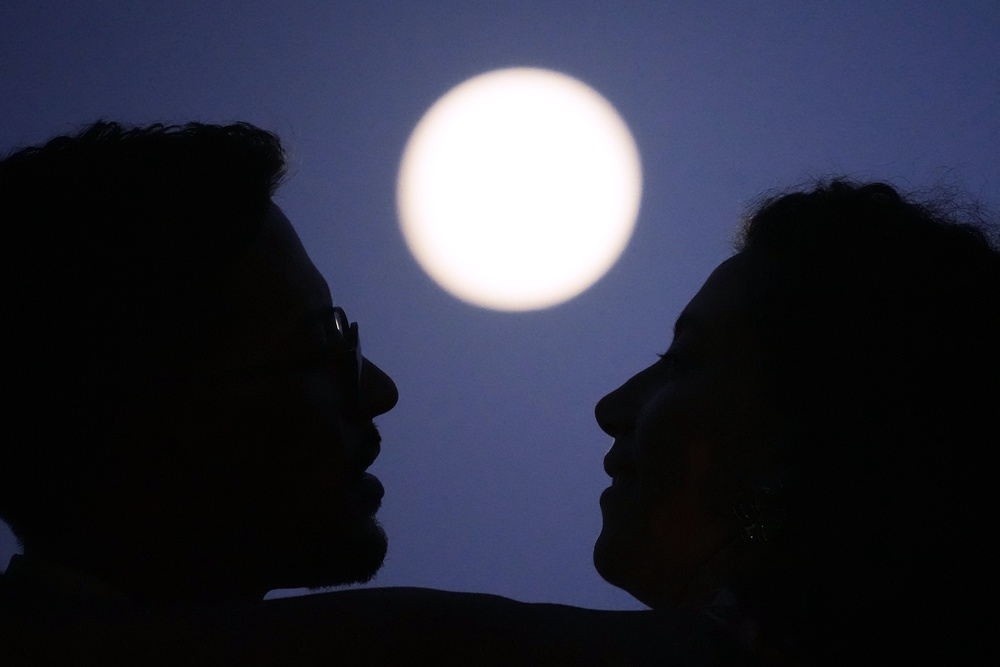 A couple embrace as the full moon rises hours before a lunar eclipse at the Santa Luzia viewpoint in Lisbon. (AP)