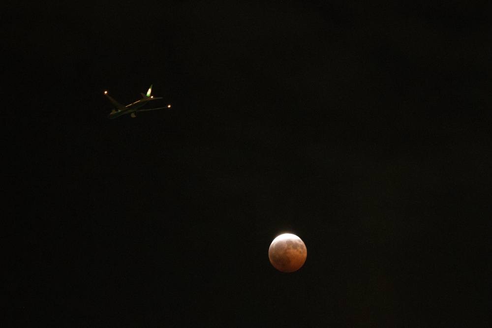 An airplane flies past a partial lunar eclipse in Los Angeles, (AP)