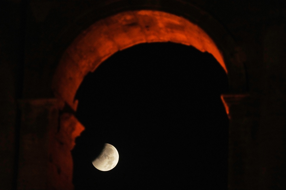 The moon sets behind the Colosseum during a partial lunar eclipse in Rome, Friday, Aug. 28, 2026. (AP)