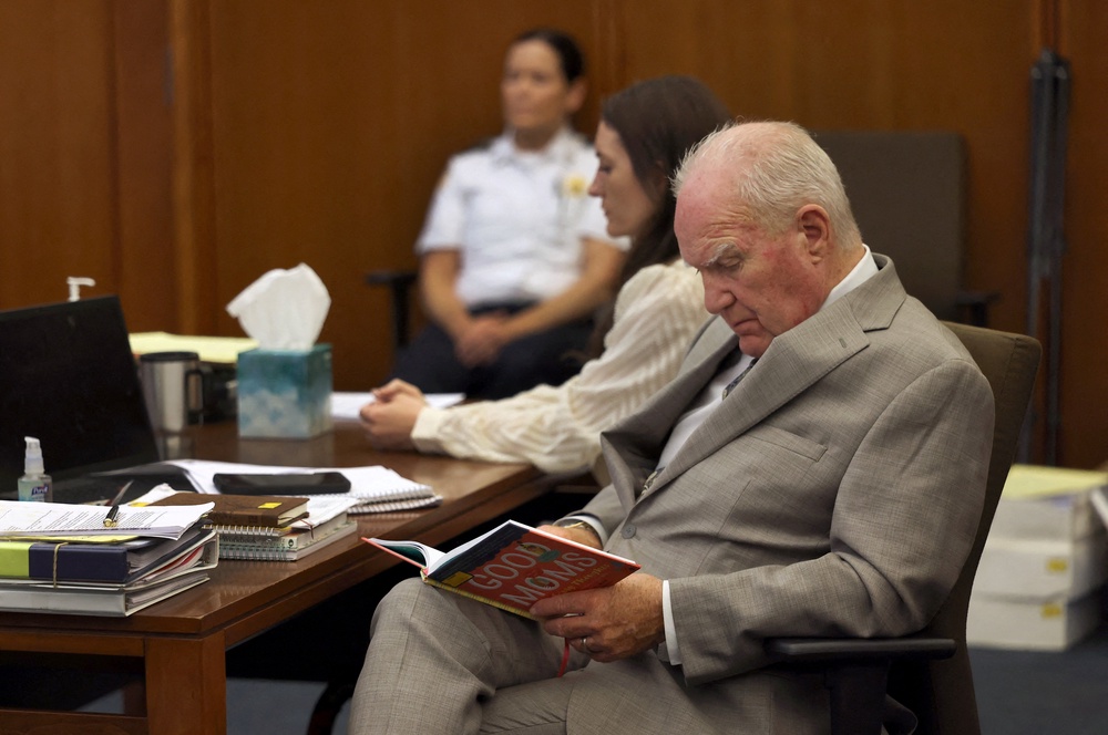 Lindsay Clancy sits beside her defense attorney Kevin Reddington as he looks over a book titled 