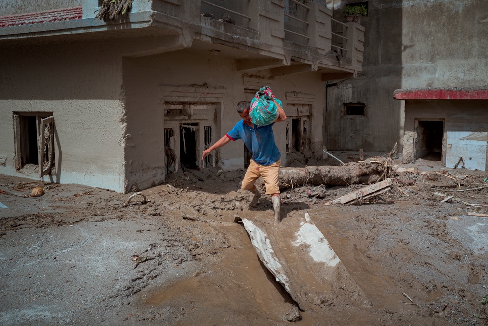 A resident carries belongings he salvaged from his destroyed home following flash floods on 28 August 2026 in Devighat, Nepal (Getty)