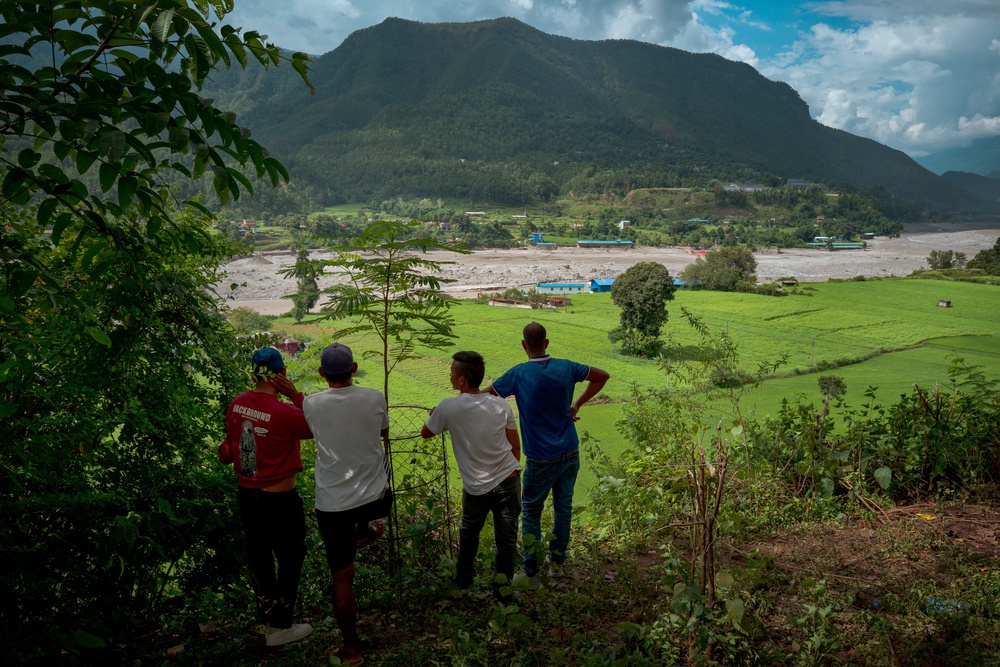 Residents view the Trishuli river from a hilltop after police alerted them of another possible surge on 28 August 2026 in Devighat, Nepal (Getty)