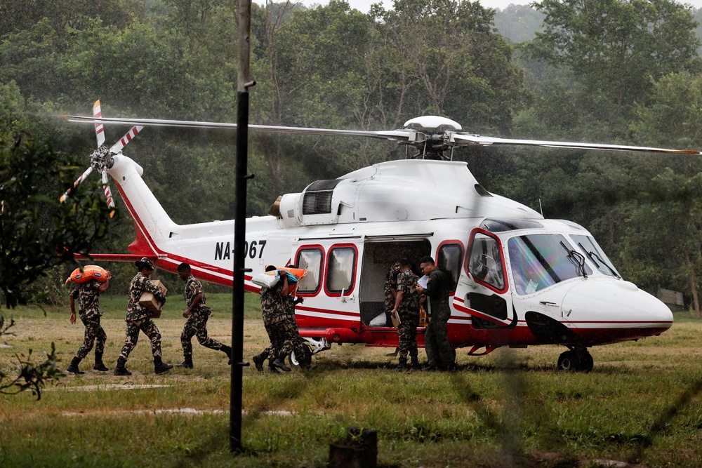 Army soldiers load relief material in a helicopter to be transported to the areas affected by flash floods and a mudslide as it drizzles at the Maithali Barrack, an army training center, in Trishuli, Nuwakot district, Nepal, 28 August 2026 (Reuters)