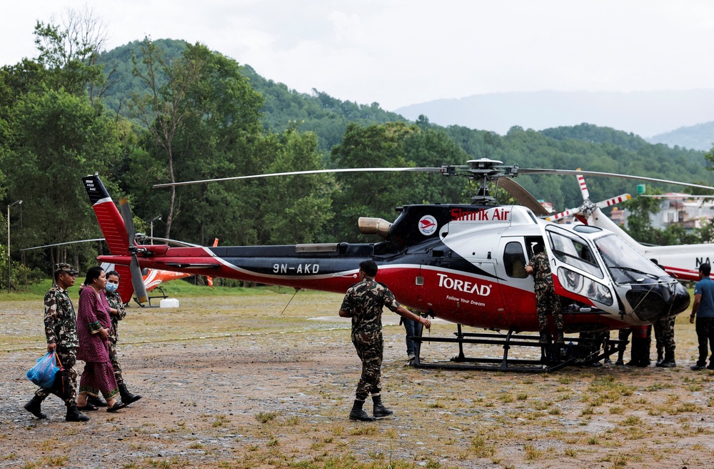 Members of the Nepal army assist a pregnant woman before she is airlifted to a hospital at the Maithali Barrack, an army training centre, following flash floods and mudslides, in Trishuli, Nuwakot district (Reuters)