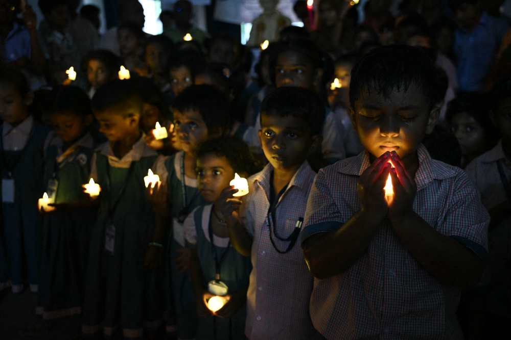 School students hold LED candles as they gather to pay their homage to people who died in Nepal's flash flood, in Chennai (AFP/Getty)
