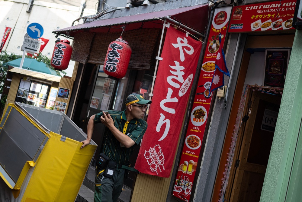 File. A delivery man looks up as he passes the Chitwan Rhino Restaurant and Bar in the Okubo district, one stop north of Shinjuku metro, in Tokyo on 12 June 2026, a neighbourhood known for its large immigrant communities, including Korean, Southeast Asian and South Asian residents (AFP/Getty)