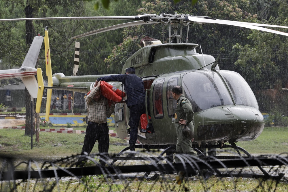 Rescuer load relief material in a helicopter to be transported to the areas affected by flash floods and a mudslide as it drizzles at the Maithali Barrack, an army training center, in Trishuli, Nuwakot district, Nepal (Reuters)