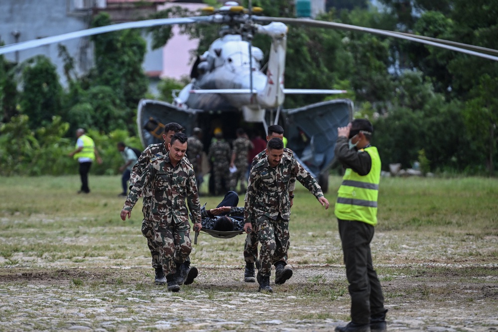 Army personnel carry an injured man during a rescue operation in the aftermath of flash floods, at Trishuli camp in Nuwakot district (AFP/Getty)