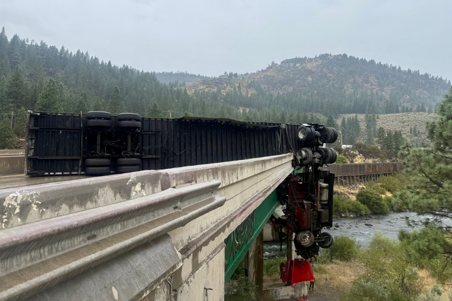 A tractor-trailer truck crashed through an I-80 railing near Truckee, California on August 28, leaving its cab dangling 80 feet above a bridge (California Highway Patrol)