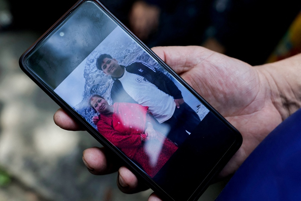 A man shows a photo of his missing family members outside the Maithili Barrack, an army training centre, which serves as a primary base to airlift survivors from Rasuwa following flash floods and mudslide at Trishuli in Nuwakot district, Nepal, August 27, 2026. (Reuters)
