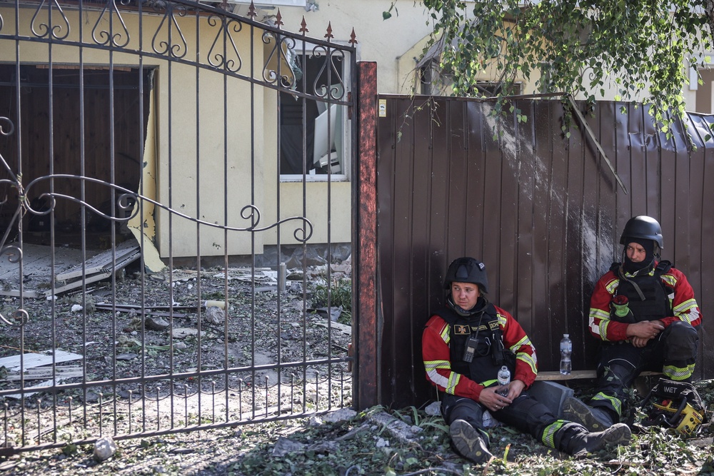 Rescuers look on near a damaged house at a site of a yesterday's Russian drone strike, amid Russia's attack on Ukraine, in the village of Myla, Kyiv region (Reuters)