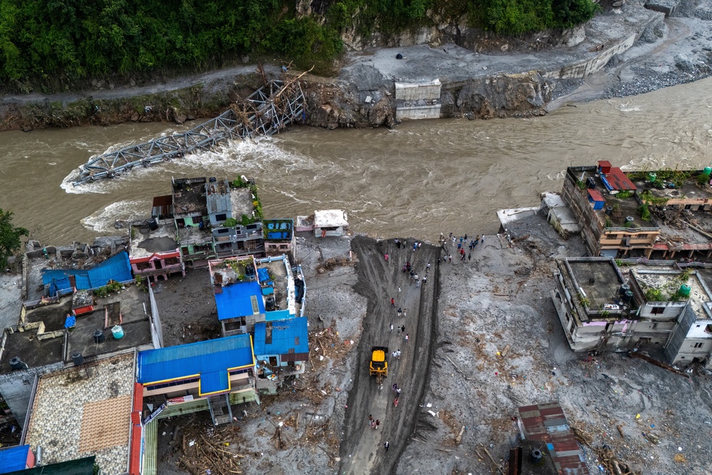 A drone view of houses in mud and the broken bridge after deadly flash floods and mudslide, at Devighat, Nuwakot district (Reuters)