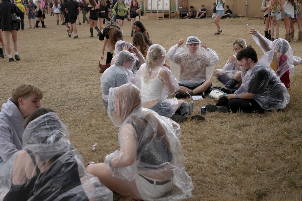 Festivalgoers shelter from the rain in plastic ponchos on the first day of Reading Festival (Jeff Moore/PA) (PA Wire)