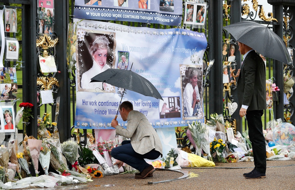 William leaves flowers as he and Harry look at tributes to Diana, Princess of Wales attached to gates of Kensington Palace ahead of the 20th anniversary in 2017