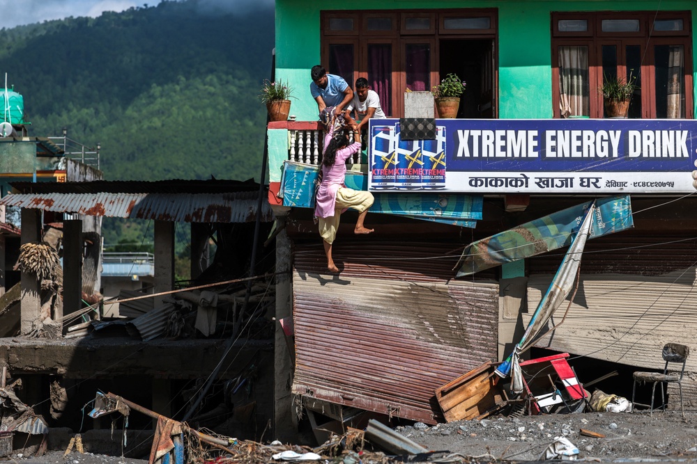 People try to enter their damaged house following deadly flash floods and mudslides, in Devighat, Nuwakot district, Nepal (Reuters)