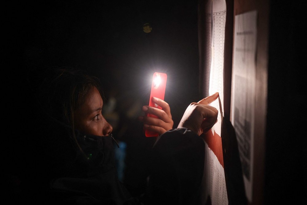 A person looks through the lists of survivors outside Maithili Barrack army training centre, in the aftermath of flash floods and mudslide, Nuwakot district, Nepal (Reuters)