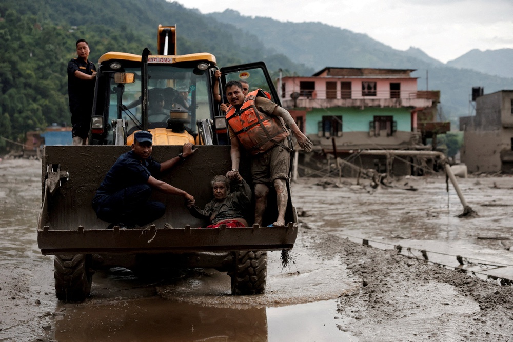 A survivor is transported to a safer place in heavy machinery following a flash flood at Trishuli in Nuwakot district, Nepal, August 26, 2026. (Reuters)