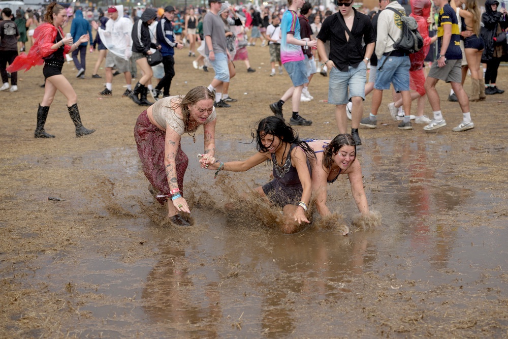 Music fans at Reading Festival donned ponchos and umbrellas, and frolicked in the mud after getting caught in downpours over the weekend