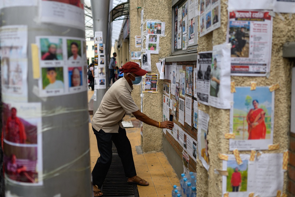 A man examines photographs of missing persons at the Tribhuvan University Teaching hospital in Kathmandu (AFP/Getty)