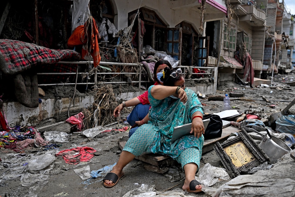 People salvage belongings following flash floods in Devighat (AFP/Getty)