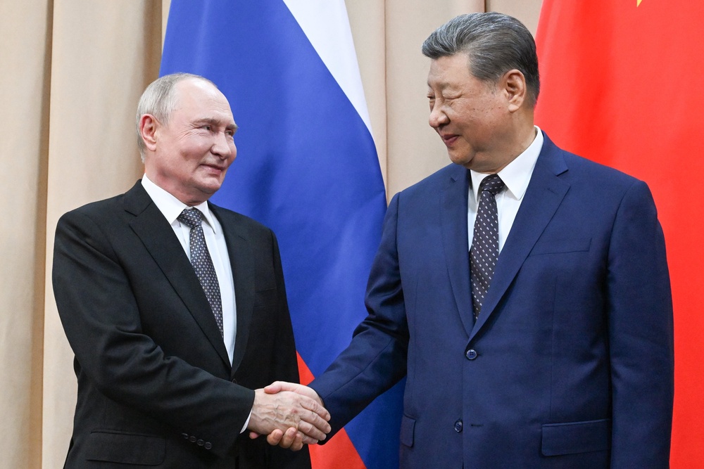 Russian President Vladimir Putin, left, and China's President Xi Jinping shake hands during their meeting on the sidelines of the Shanghai Cooperation Organization (SCO), in Bishkek, Kyrgyzstan (AP)