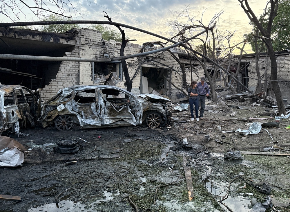 Residents walk at a site of a Russian missile strike, amid Russia's attack on Ukraine, in the town of Borispil, Ukraine (Reuters)