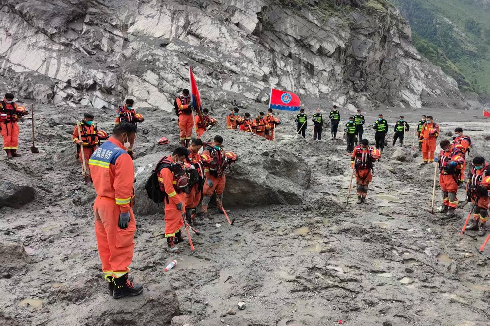 Rescuers observe a moment of silence near the Gyirong Port in Tibet (AP)