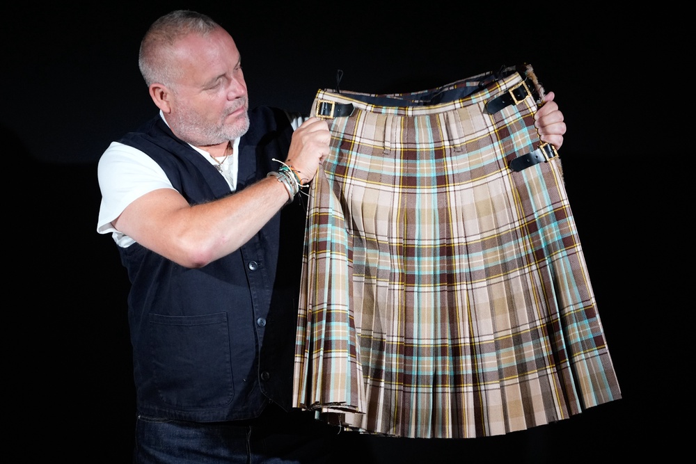 Mark Hochman holds a Vivienne Westwood kilt worn by Sex Pistols guitarist Steve Jones on the Filthy Lucre Tour (PA)