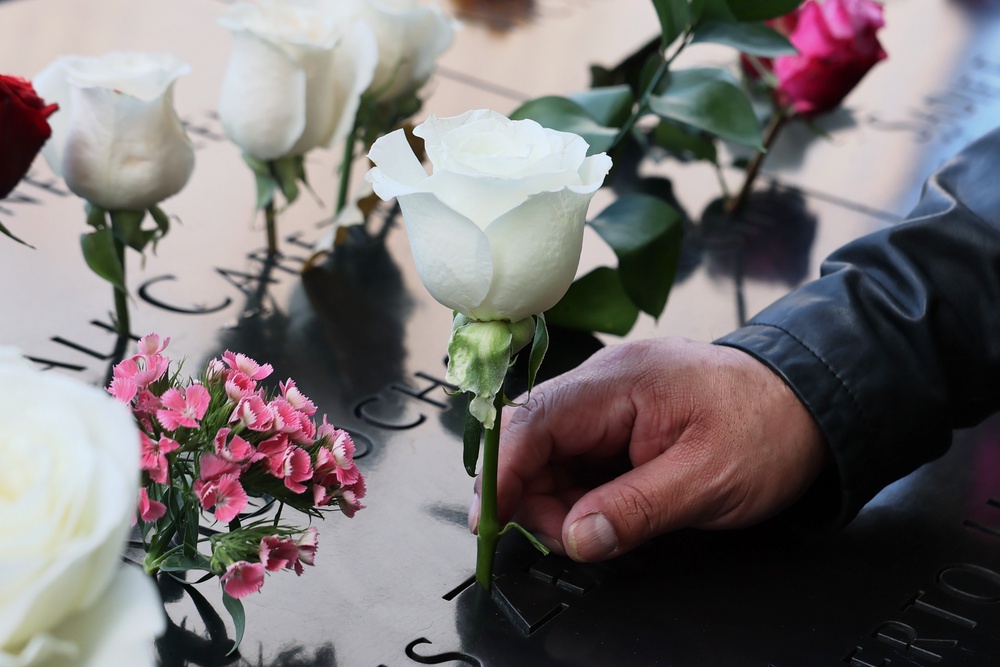 A man places flowers on the name of a loved one, a victim of the 9/11 terror attack (Getty)