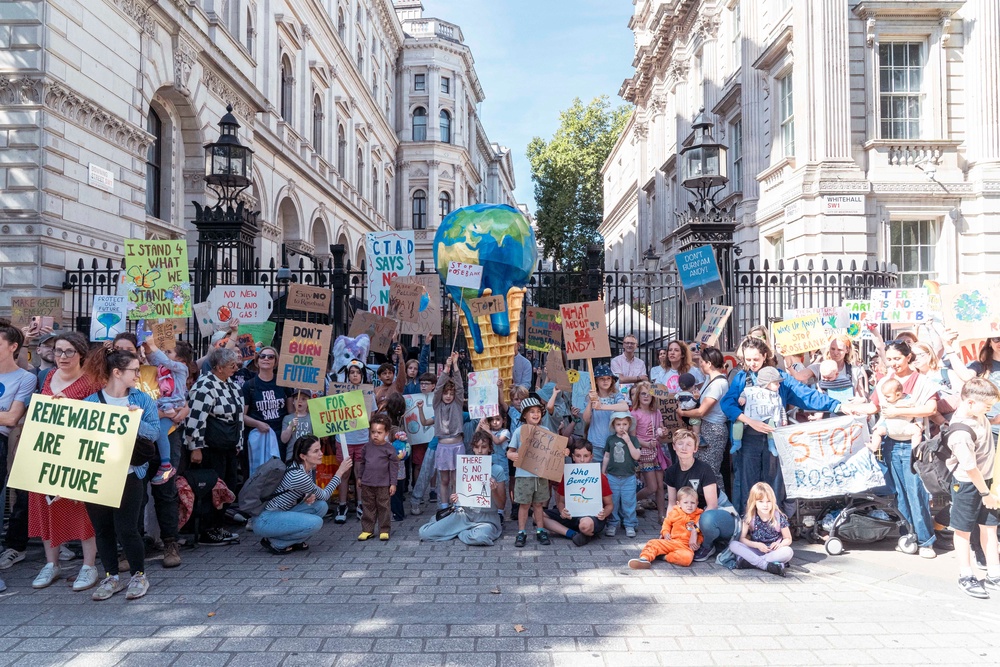 Mothers and children with Mothers Rise Up gather outside 10 Downing Street with a giant melting-planet ice cream, calling for urgent action to protect children from extreme heat (Denise Laura Baker / Mothers Rise Up)